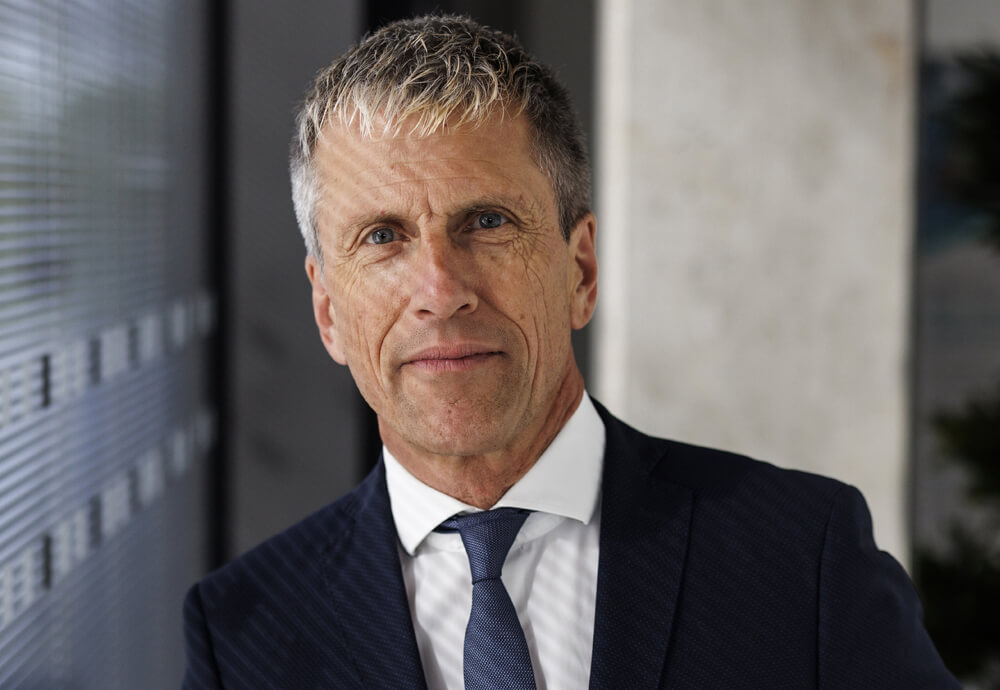 Geschäftsmann in moderner Büroarchitektur – Analyse und Reporting mit dem Fonds-Tool IP Performance.