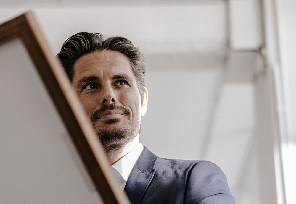 Geschäftsmann hält ein Bild in der Hand – individuelle, maßgeschneiderte Lösungen für Fonds.