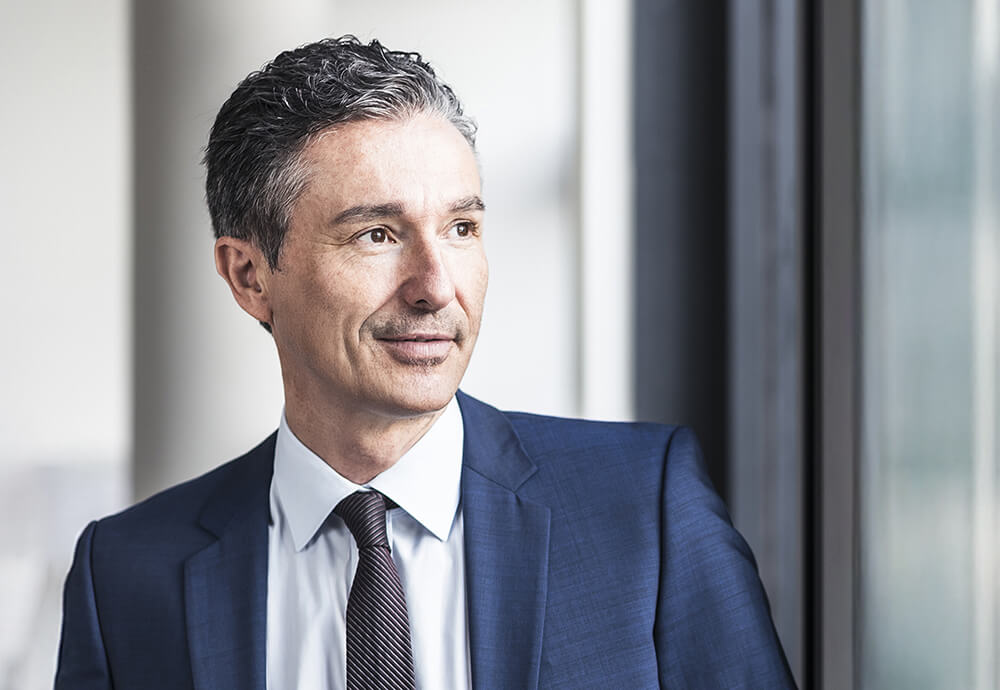 Geschäftsmann blickt zuversichtlich aus dem Fenster – Partnerschaft und Wachstum durch professionellen Vertriebsservice.