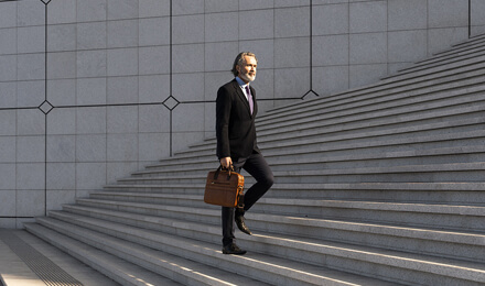 Geschäftsmann steigt eine Treppe hinauf – Transparenz und Struktur im Fondsreporting mit IP Reporting.