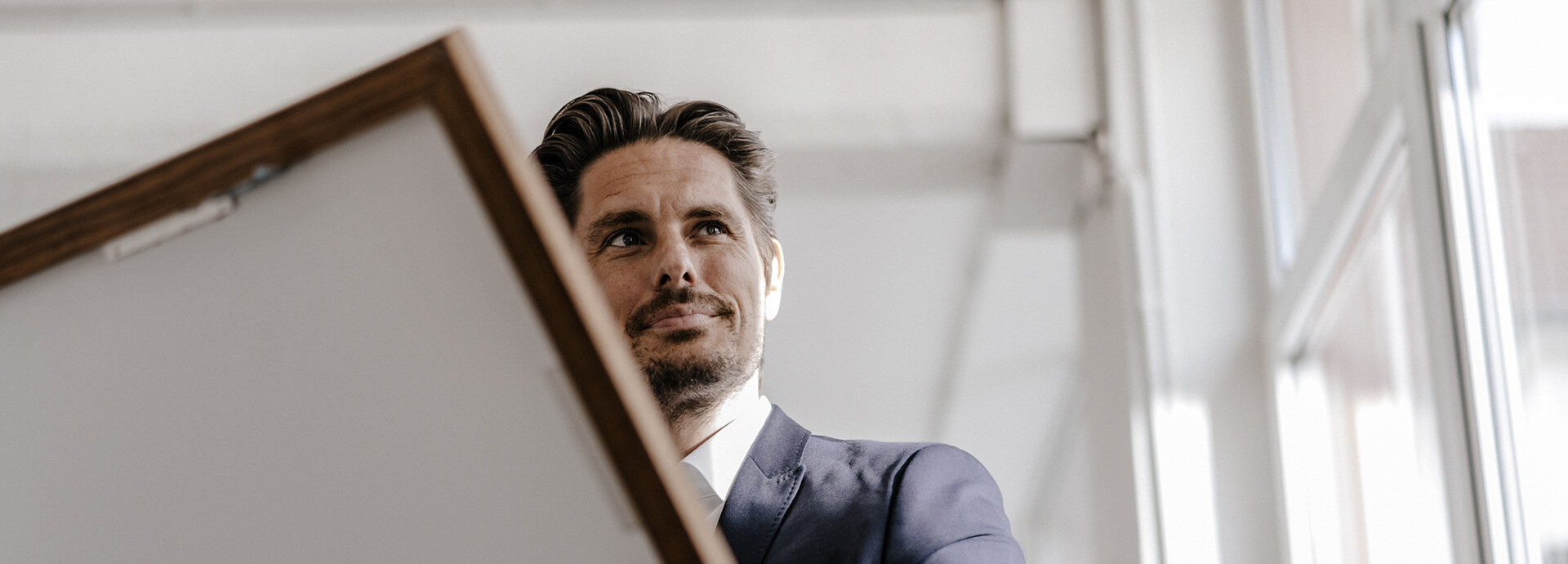 Geschäftsmann hält ein Bild in der Hand – individuelle, maßgeschneiderte Lösungen für Fonds.