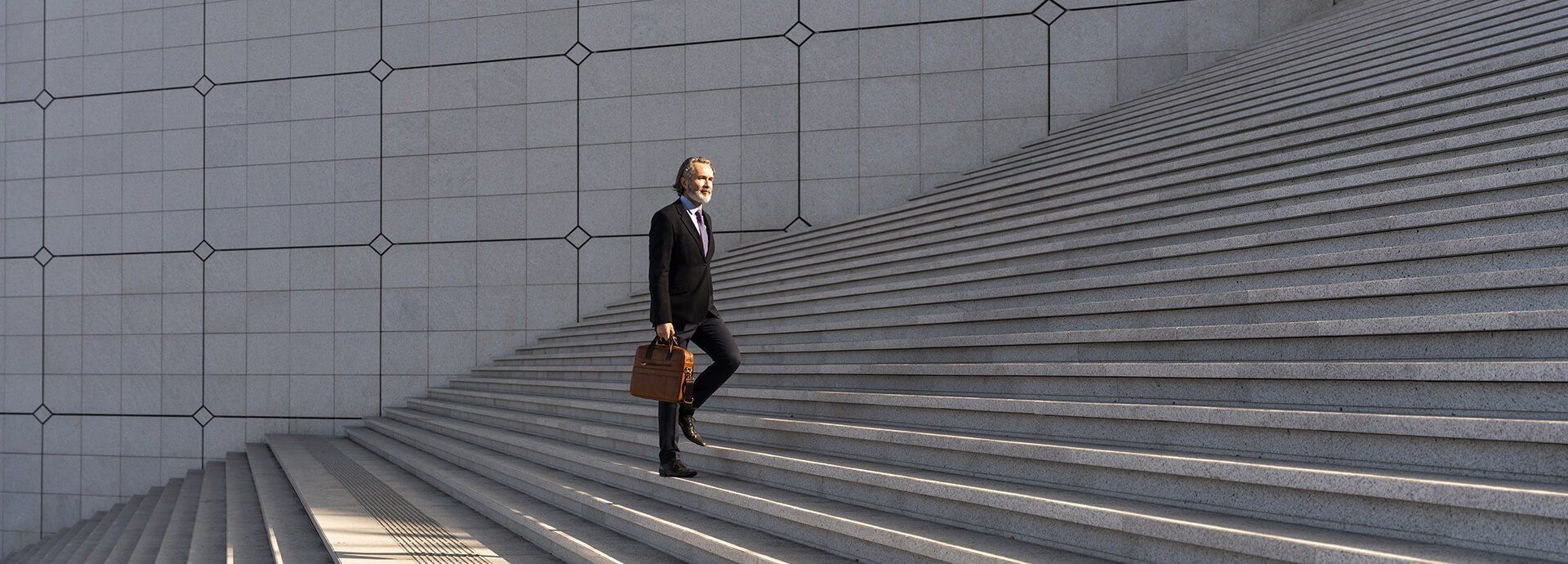 Geschäftsmann steigt eine Treppe hinauf – Transparenz und Struktur im Fondsreporting mit IP Reporting.