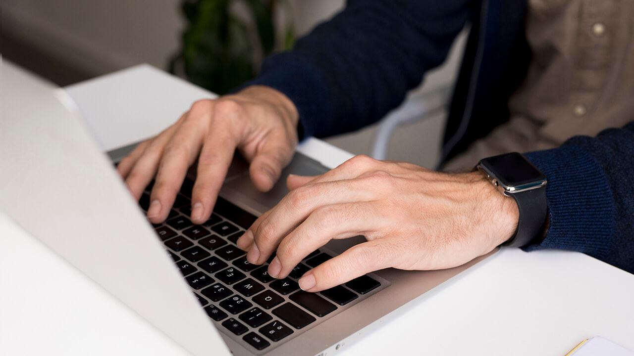 Nahaufnahme eines Geschäftsmanns am Laptop – er nutzt das Tool IP Risk für professionelles Risikomanagement.