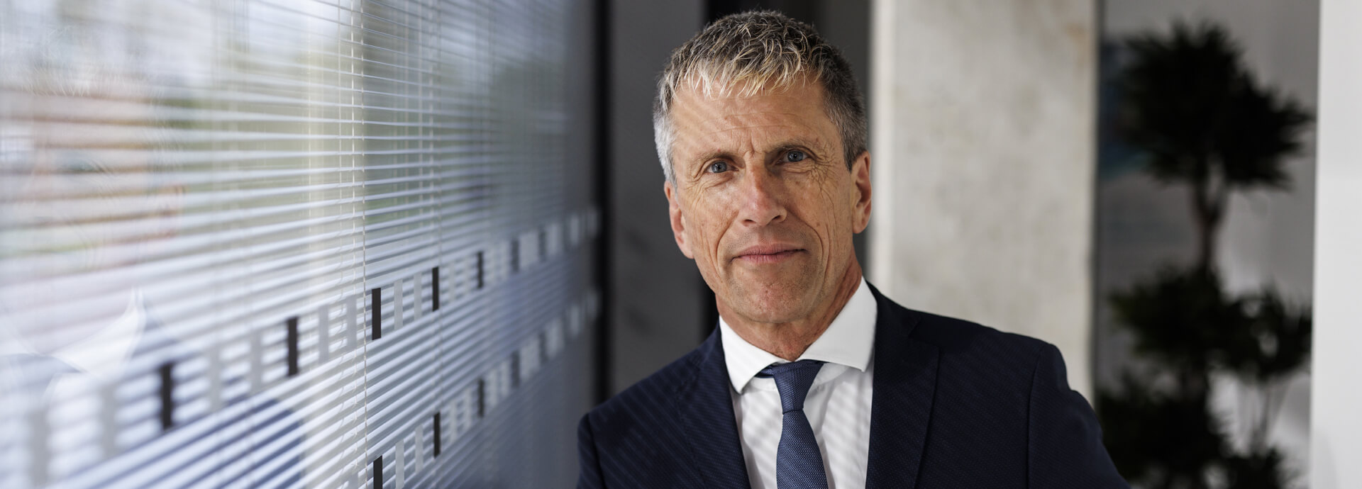 Geschäftsmann in moderner Büroarchitektur – Analyse und Reporting mit dem Fonds-Tool IP Performance.