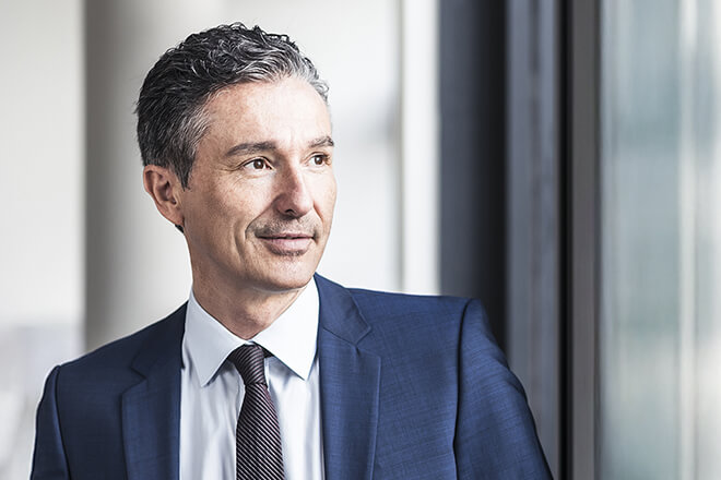 Geschäftsmann blickt zuversichtlich aus dem Fenster – Partnerschaft und Wachstum durch professionellen Vertriebsservice.