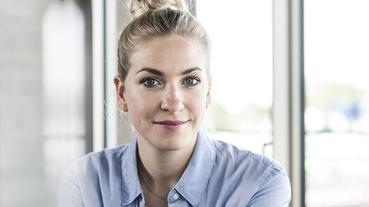 Junge Frau mit freundlichem Blick – Karrierechancen und attraktive Mitarbeitervorteile bei IPConcept.